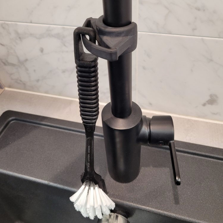 Washing up brush holder for the tap