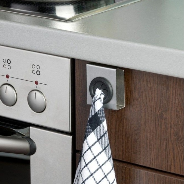 Smart hängare där du trycker i handduken eller disktrasan. Lätt att hänga upp på skåpsdörren. Passar 2 cm tjocklek.