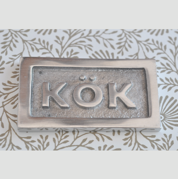 Sign with frame, KÖK, 6,5 x 3,5 cm, Exmez, Sand-cast aluminum