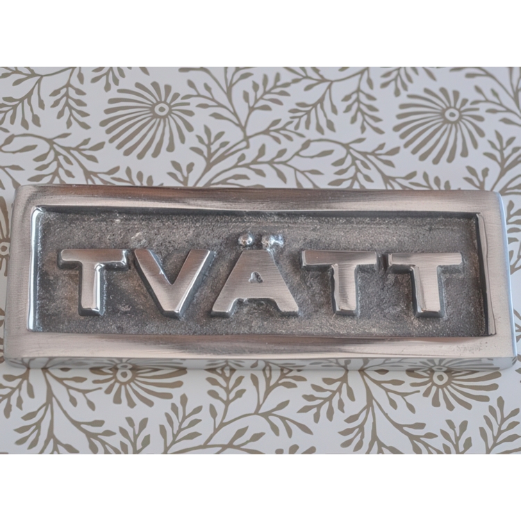 Sign with frame, TVÄTT, 9 x H 3,5 cm, Exmez, Sand-cast aluminum